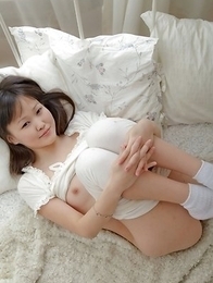 Aliana is sitting on her bed wearing white and smiling at the camera. Aliana is sitting on her bed wearing white and smiling at the camera.